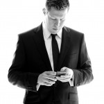 Banff Wedding Photographer | The Rimrock Hotel | Black and white portrait of a groom | on Cell phone