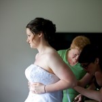 Christine & Peter Valley Ridge Golf Course wedding | Calgary Wedding Photography | Bride gazing out window getting dress laced up