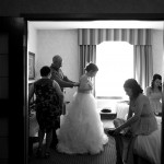Calgary wedding photographer | Bride getting dress done up by mom and dad