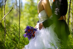 Calgary wedding photographer | Fish Creek Park wedding photos | Groom holding flowers and hugging bride in birch trees
