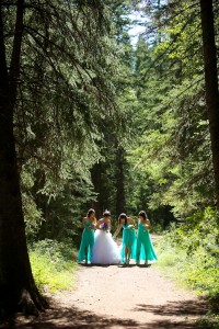 Calgary wedding photographer | Fish Creek Park wedding photos | Bride and bridesmaids walking down dirt path in tall trees