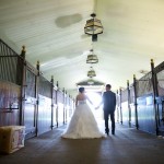 Calgary wedding photographer | Spruce Meadows wedding photos | Bride and groom walking down a horse stable