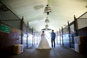 Calgary wedding photographer | Spruce Meadows wedding photos | Bride and groom walking down a horse stable