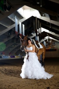 Calgary wedding photographer | Spruce Meadows wedding photos | Bride standing with a horse in a warmup ring